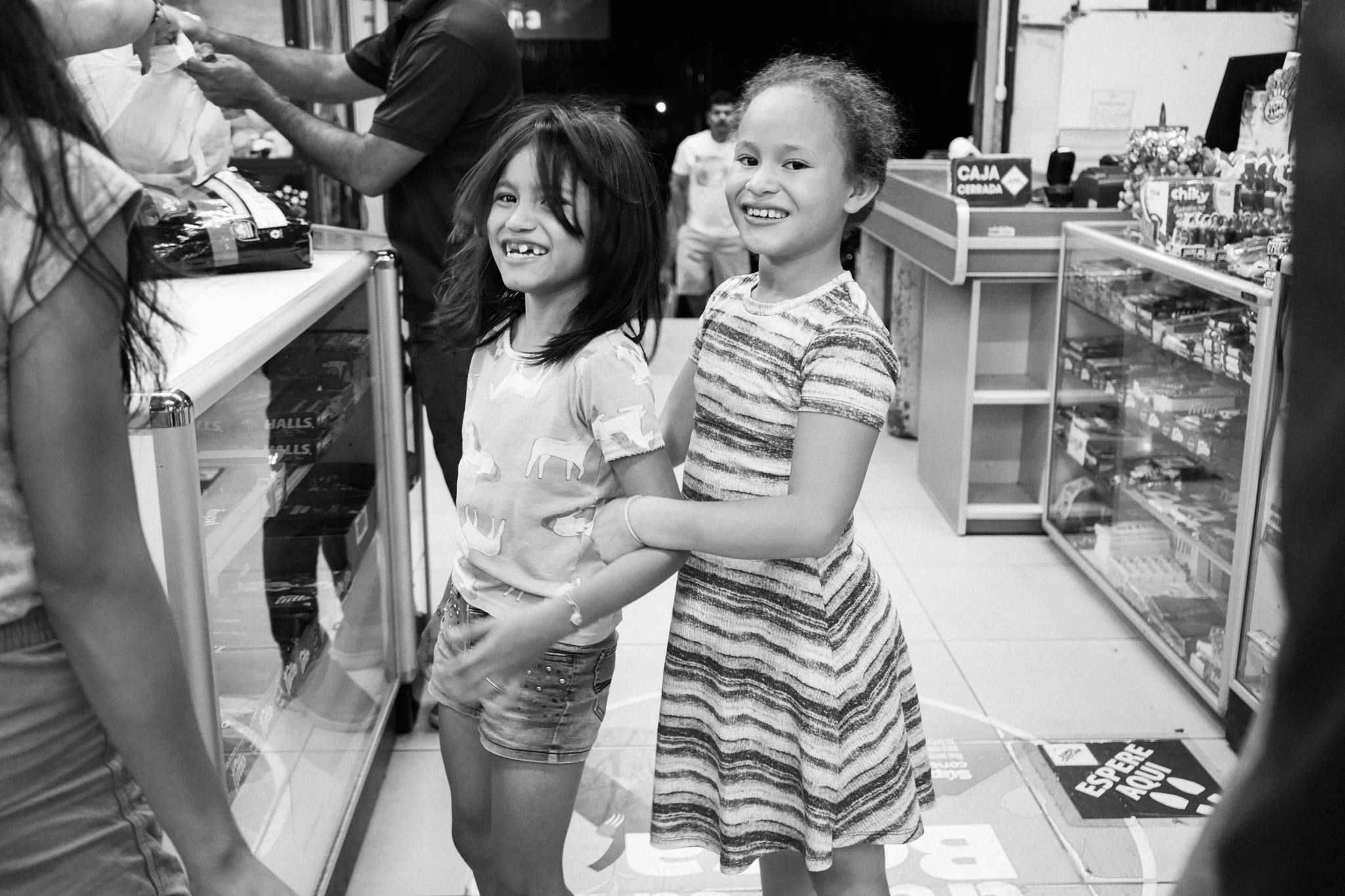 Two girls smiling in a convenience store