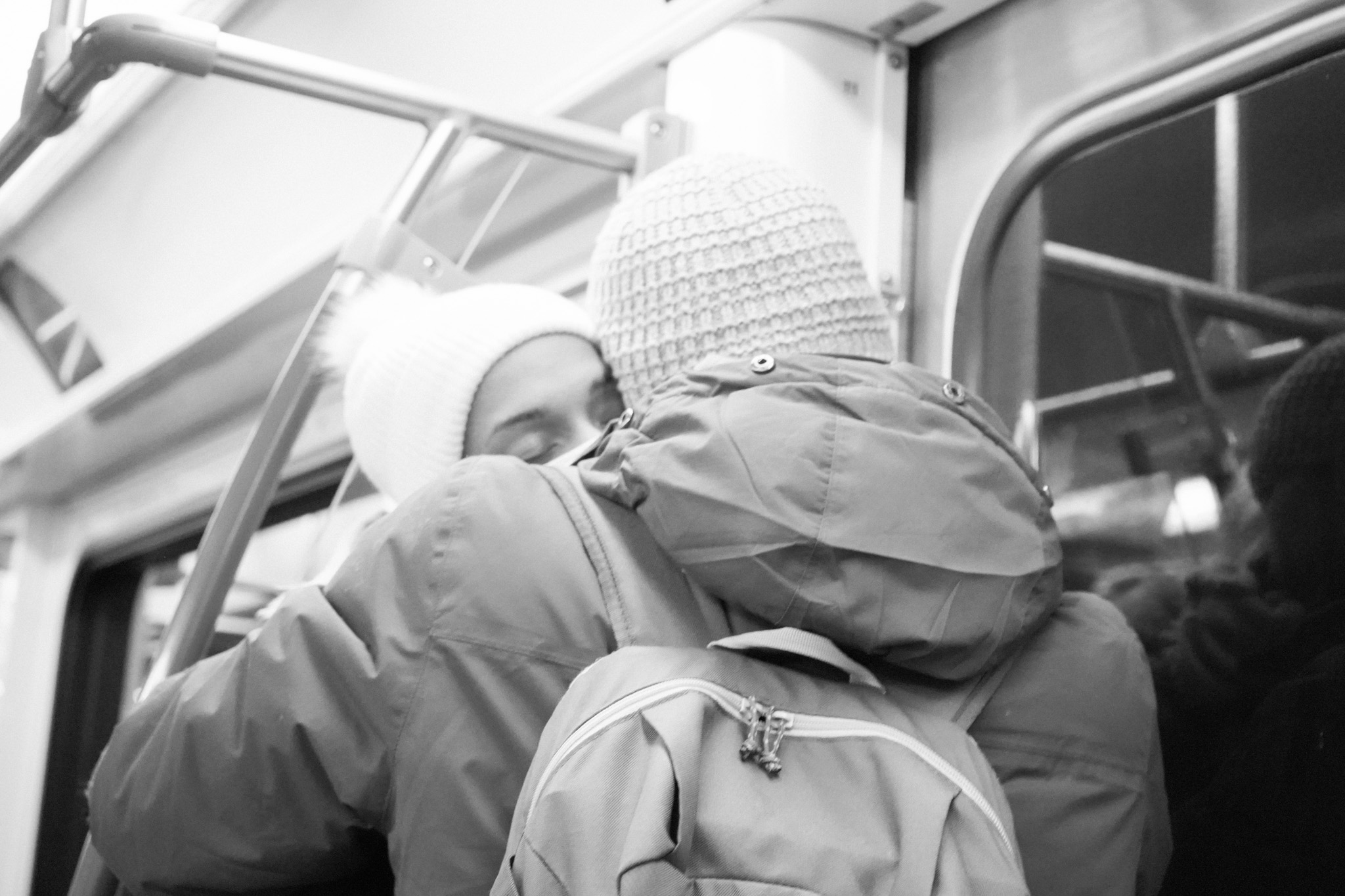 Couple in winter coats embracing on the train