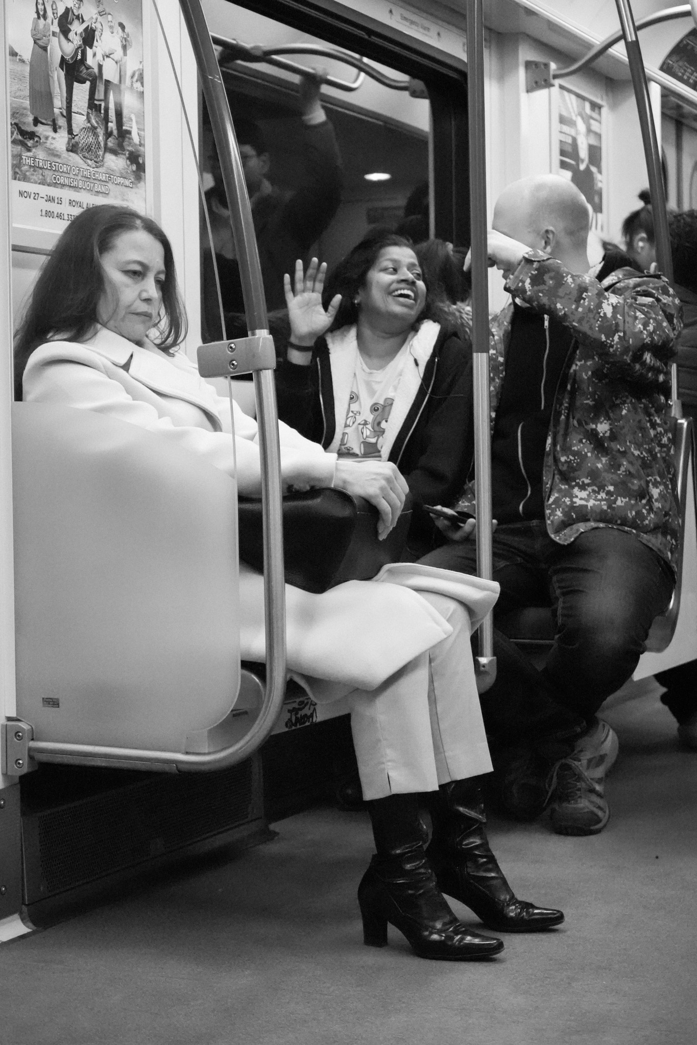 Woman seated still while another laughs behind her on the TTC