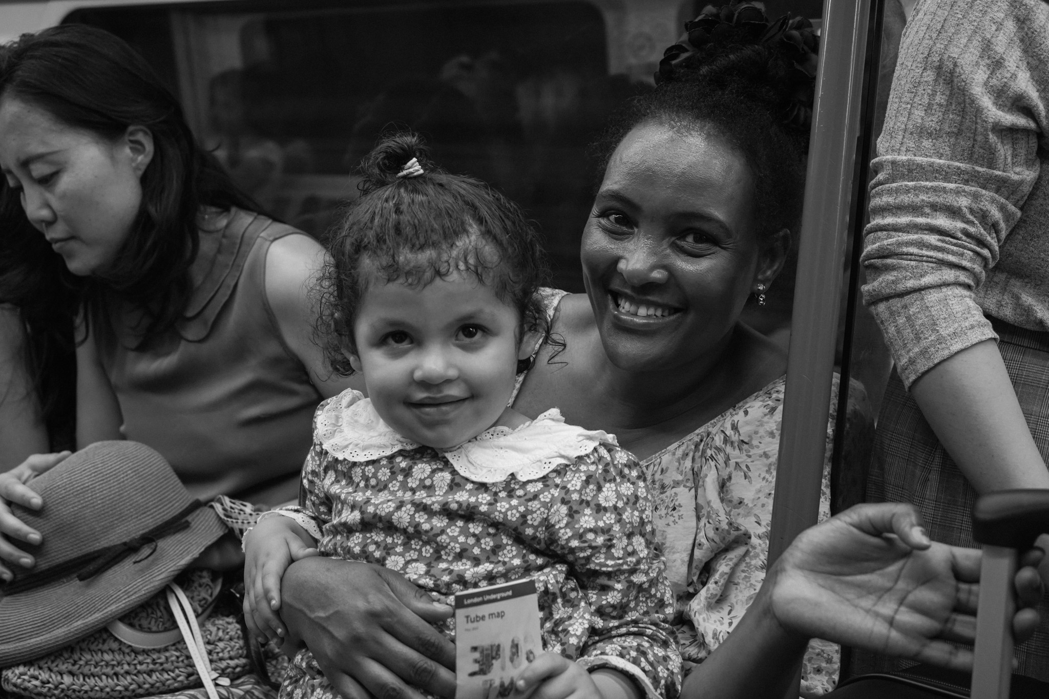 Mother and daughter smiling together on the tube