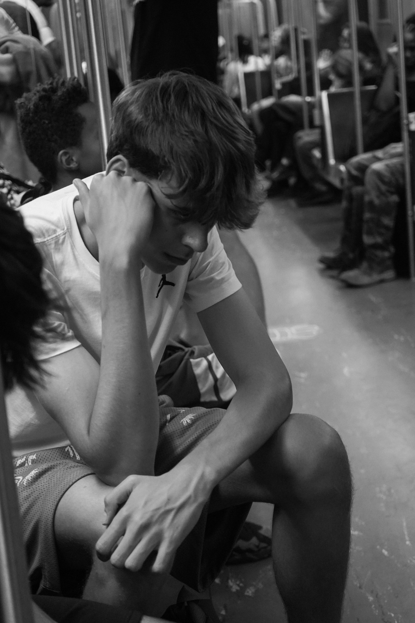 Boy sitting with head in hand, deep in thought