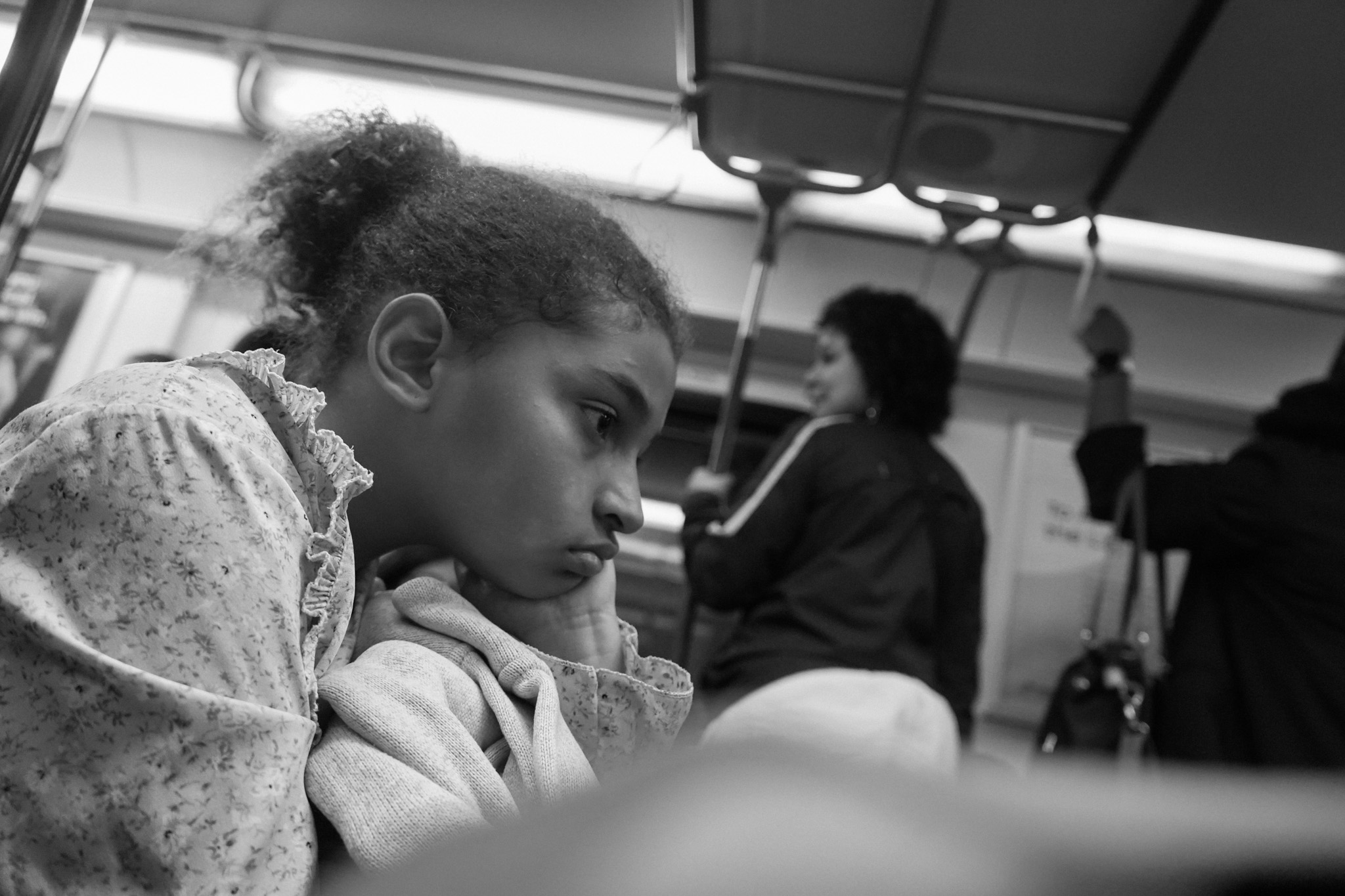 Young girl gazing ahead, chin resting on her hand
