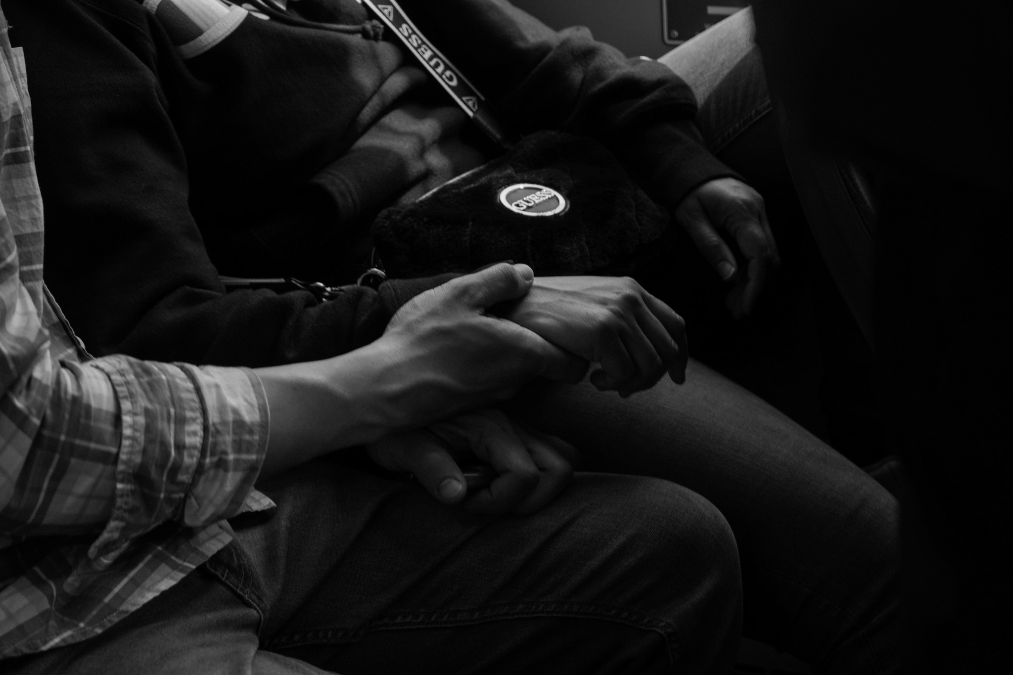 Two hands held together in a dark carriage